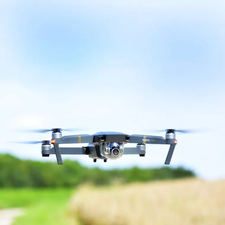 Квадрокоптер DJI Mavic Pro зависает над травой